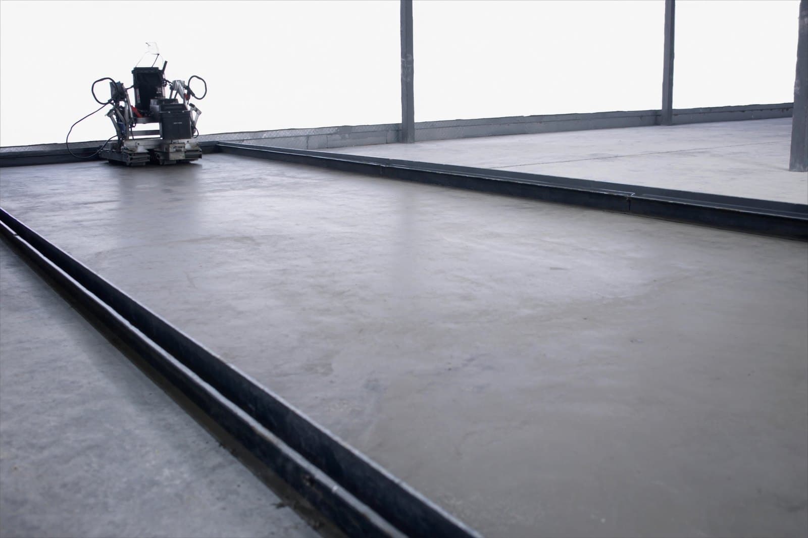 Power trowel finishing a commercial concrete floor slab