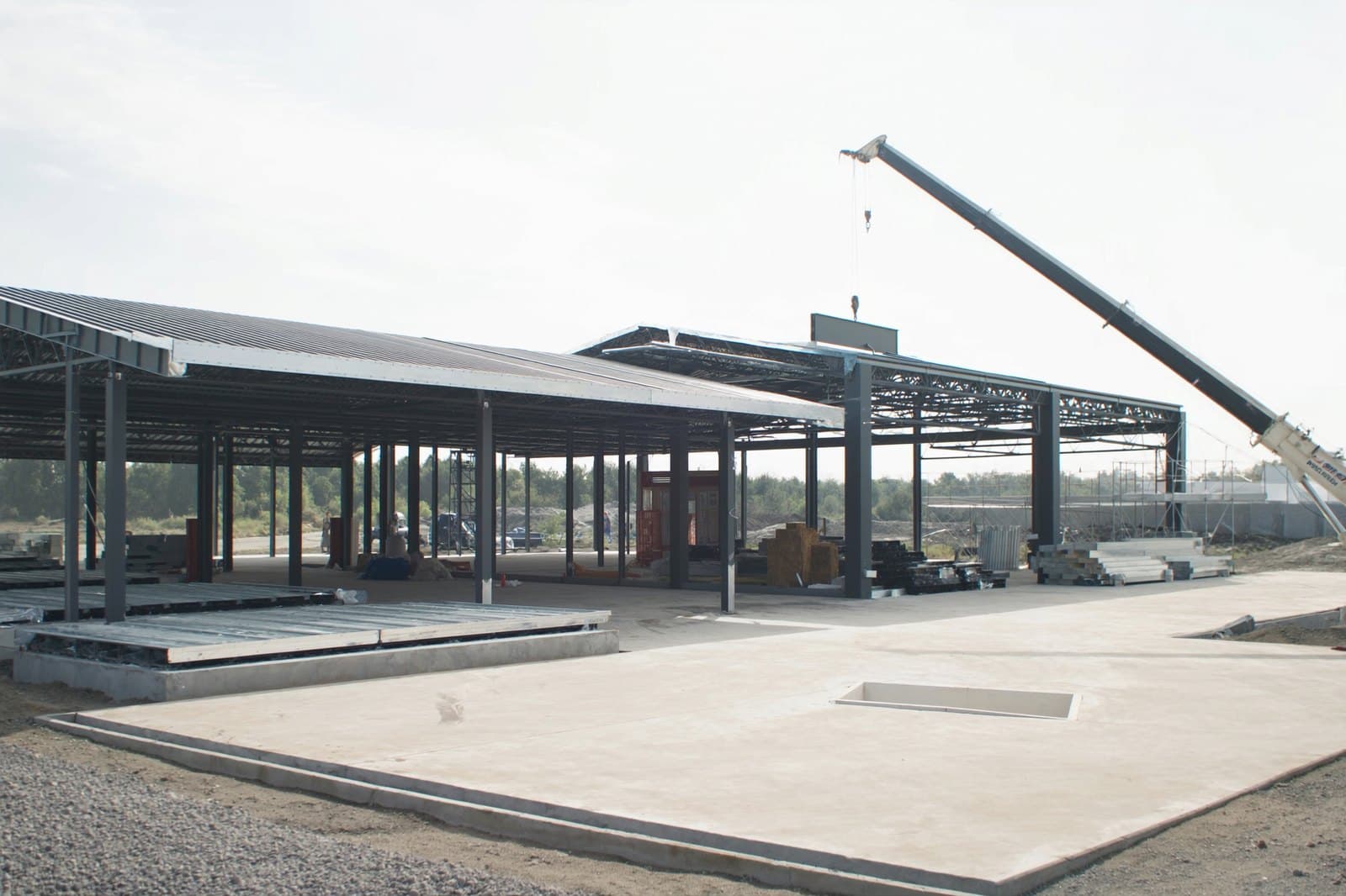 Steel building frame mid erection with a mobile crane